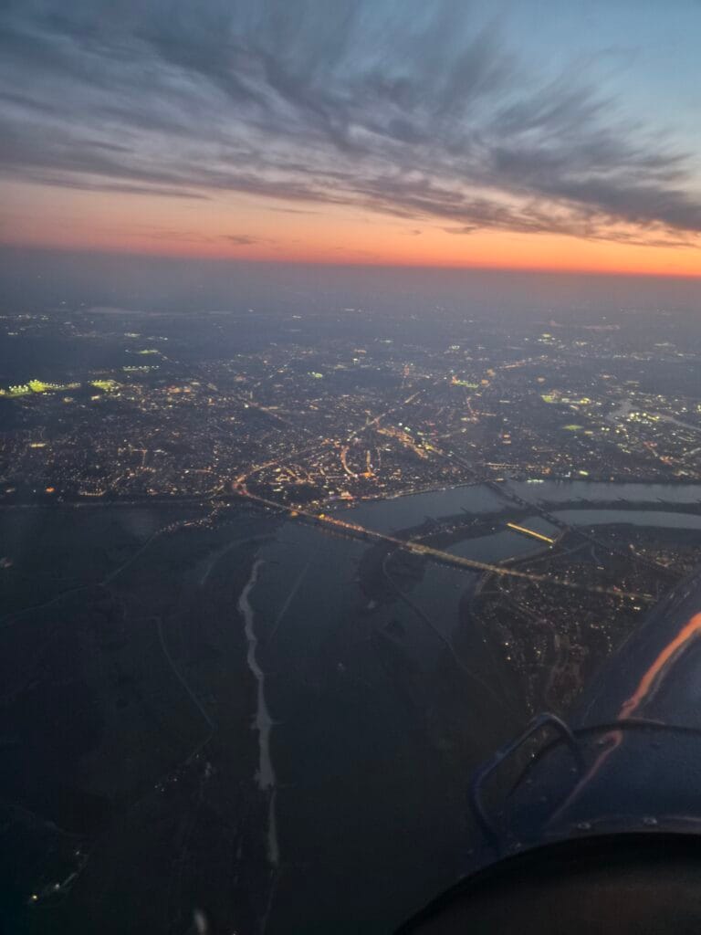 Night flight above a city at sunset