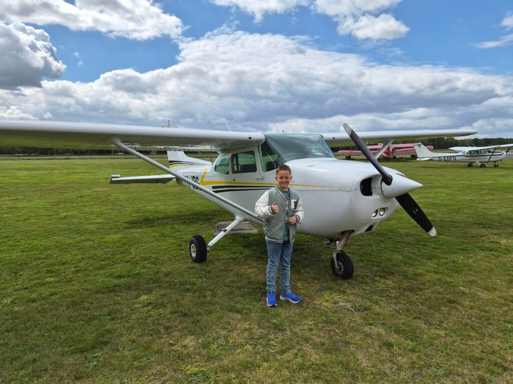 Young passenger standing in front of Cessna PH-JBG at the airfield